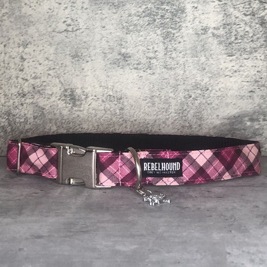 Pink plaid dog collar with metal buckle on a gray surface